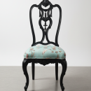 vista frontal de silla antigua actualizada en negro con respaldo tallado y patas cabriolé